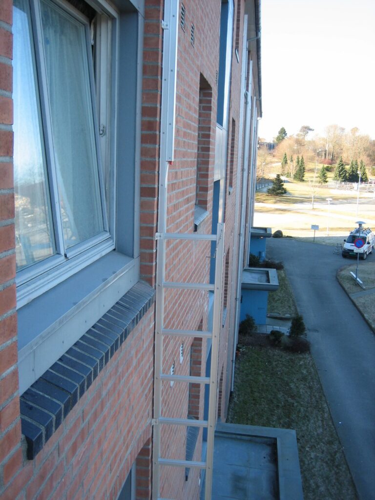 A side view of apartment building with emergency fire escape ladder