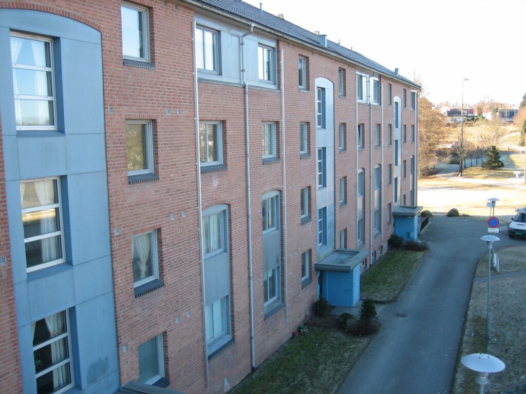 A side view of an apartment building with emergency fire escape ladders