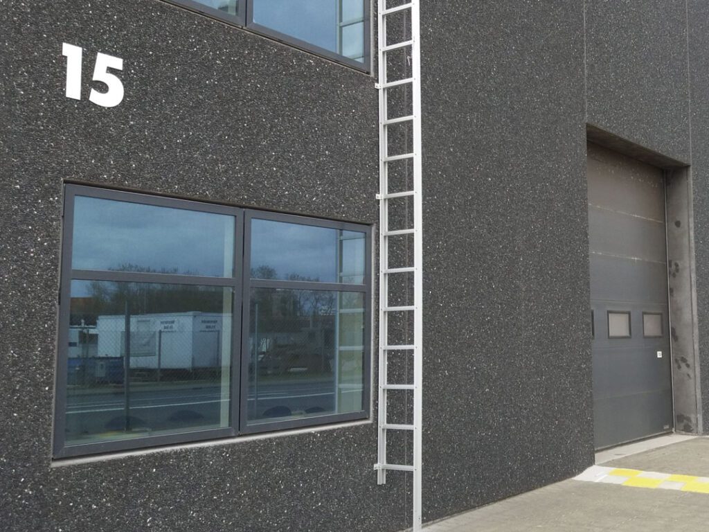 A side view of aa commercial building with emergency fire escape ladder