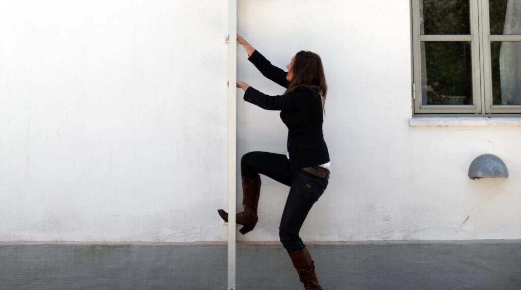 A lady climbing down an emergency fire escape ladder